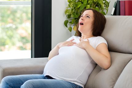 thumbnail Eine Schwangere Frau sitzt auf dem Sofa und hat Atemnot