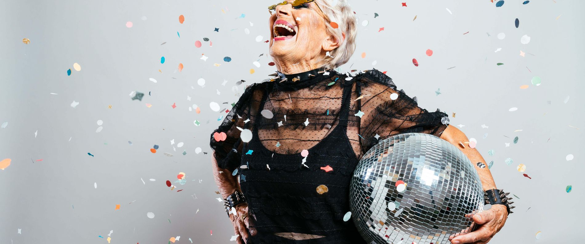 Longevity: ältere Frau mit Diskokugel und Lebensfreude